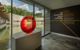 Interior with large windows, red glass sculpture, modern building, and American history text.