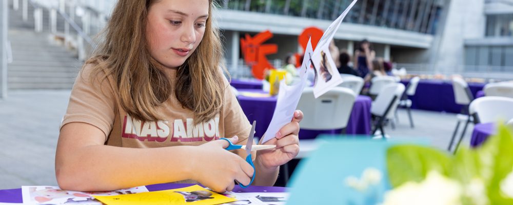 tween girl cutting out images for use in a collage project